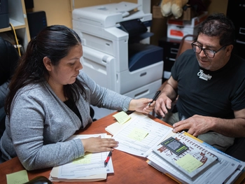 Woman helps man complete paperwork for rental assistance.